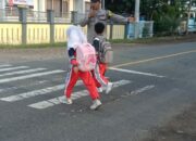 Wujud Polisi Humanis, Brigadir Wawan Satria Atur Lalu Lintas Saat Anak Sekolah di Desa Goa